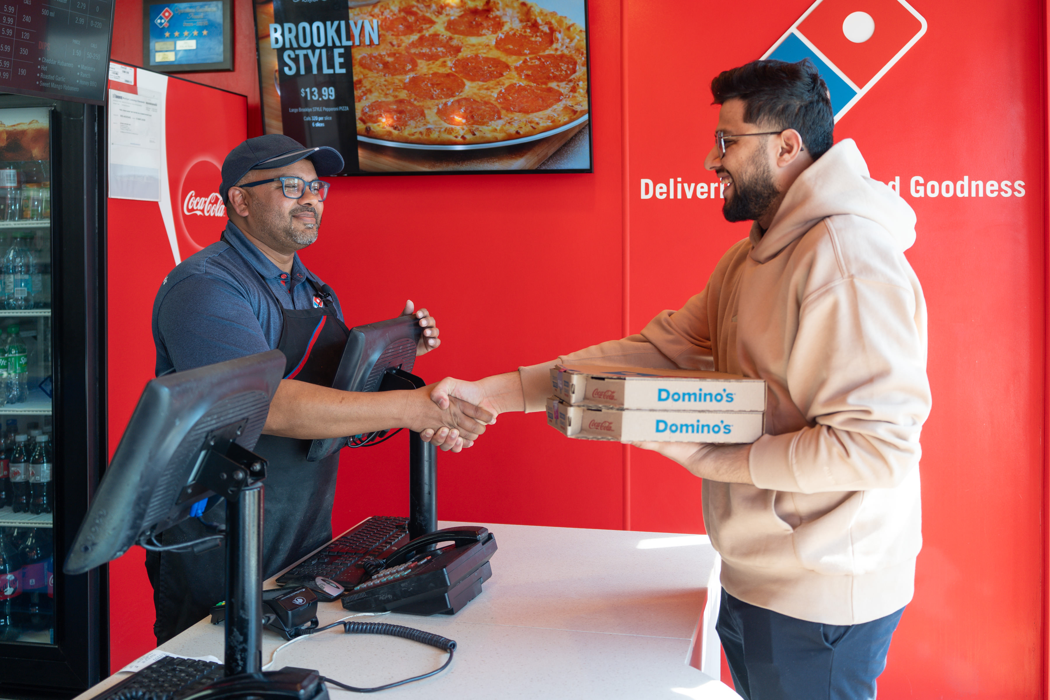 Giving pizza to customer at Dominos